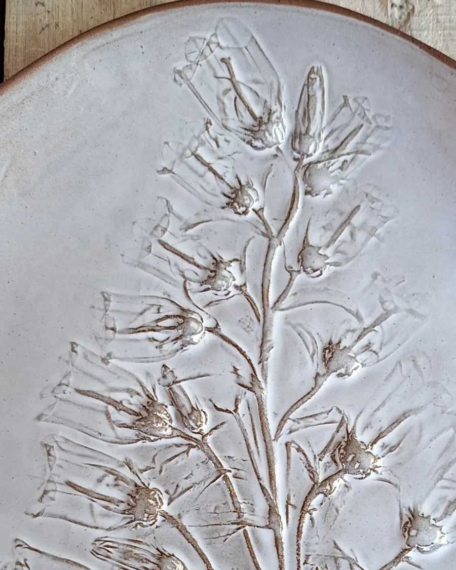 Glazed platter with plants pressed into the clay surface in relief